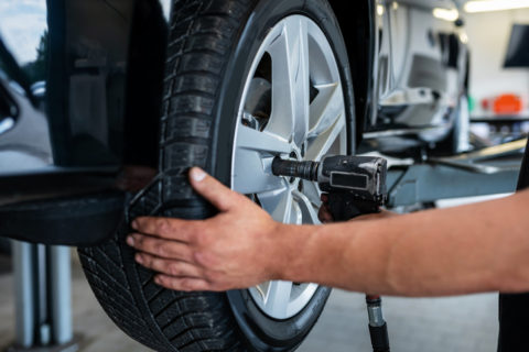 Mechanic changing tire in a car repair shop
